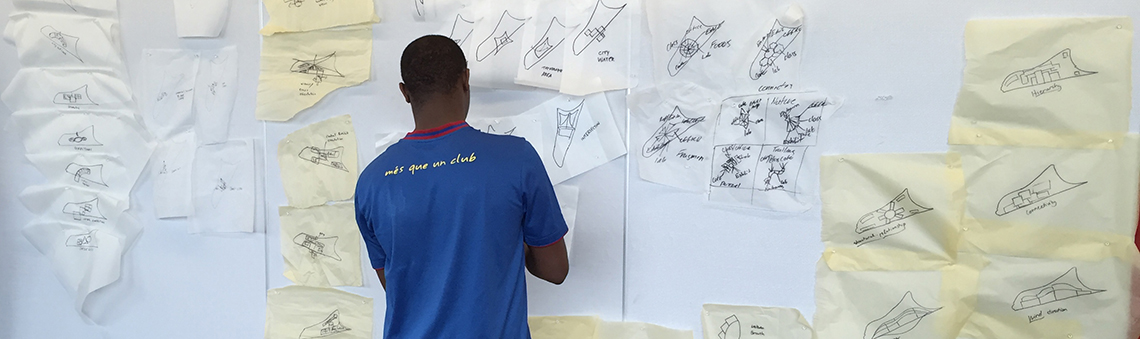 student at whiteboard, putting-up a post-it note