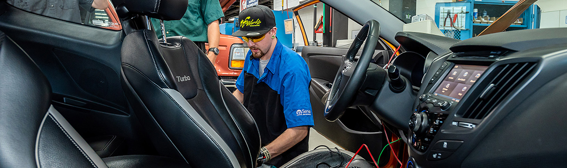 Student working on open door of car