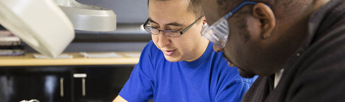 students working under desk light wearing glasses