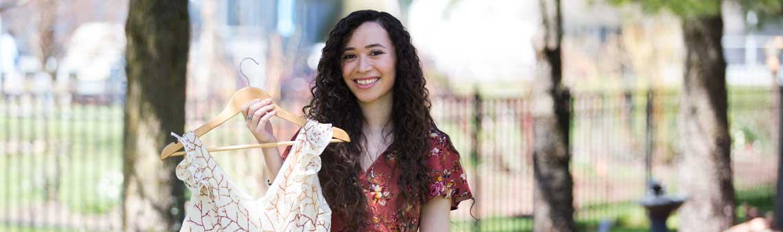 Fashion studies student holding dress on a hanger