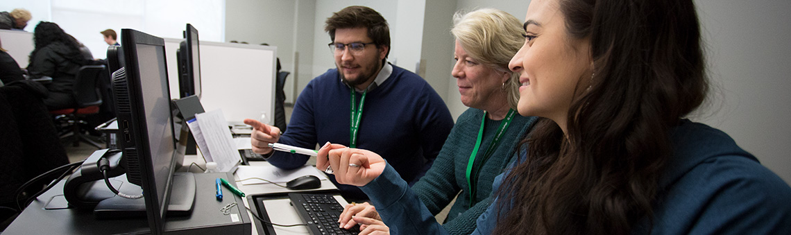 student working with advisors at a computer