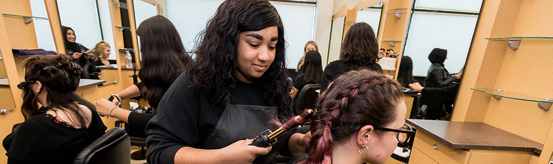 cosmetology student styling hair