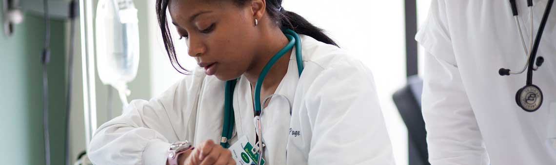 female nursing student taking vital signs of patient