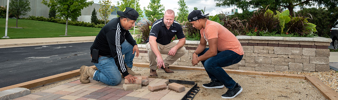 Male students working with professor outside