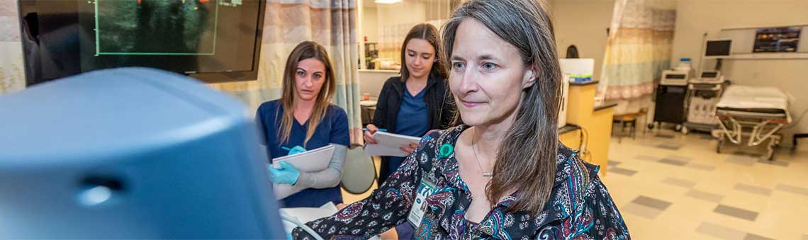 sonography students working with faculty member