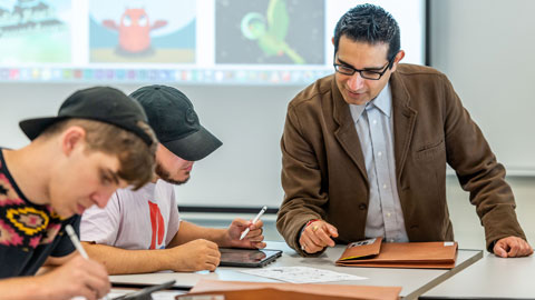 graphic design teacher working with students who are drawing