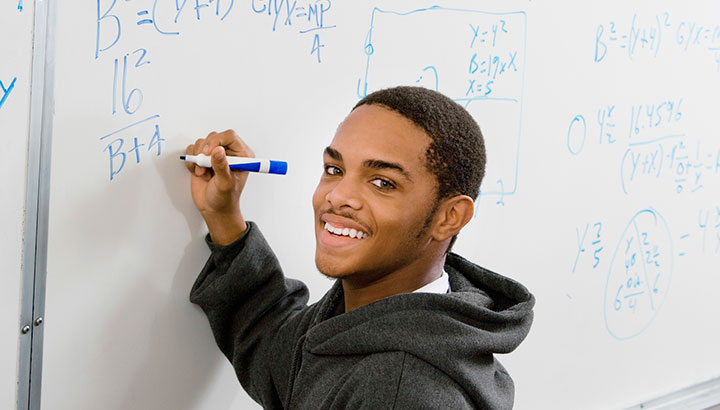 african american student writing on white board