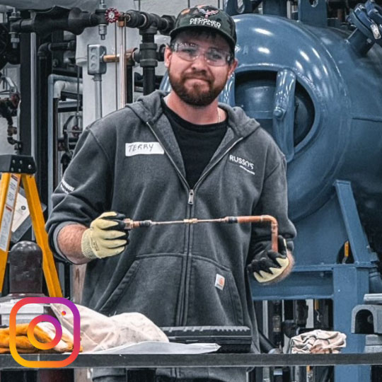 student holding a manufacturing pipe