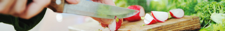 Radishes being cut on wooden board