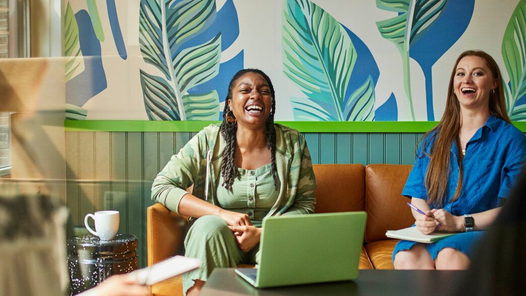 Two people in a conference room laughing