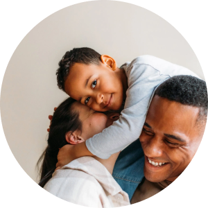 A man and a woman share a hug with a young boy