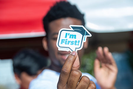 First Gen student holding a sticker that reads I'm First