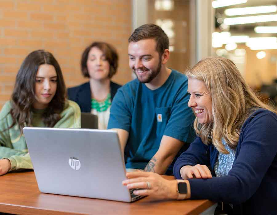 group of ksu students looking at a laptop.