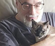 Adam-Troy Castro. A sixty-year old bearded white male showing extreme love for a cat of siamese ancestry.