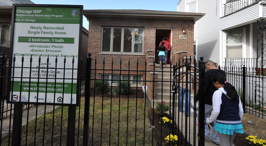 A boy smiles as he peeks out of a green box.