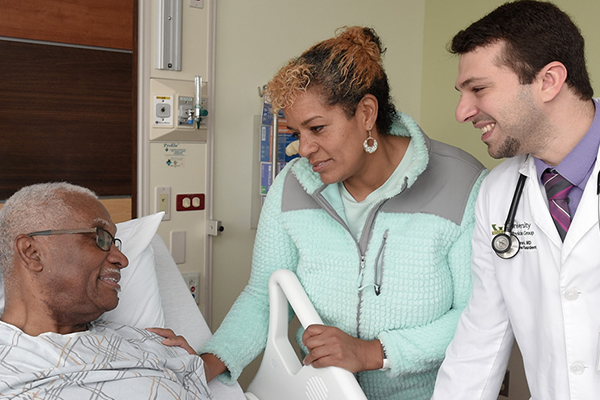 Medical residents and patient in bed