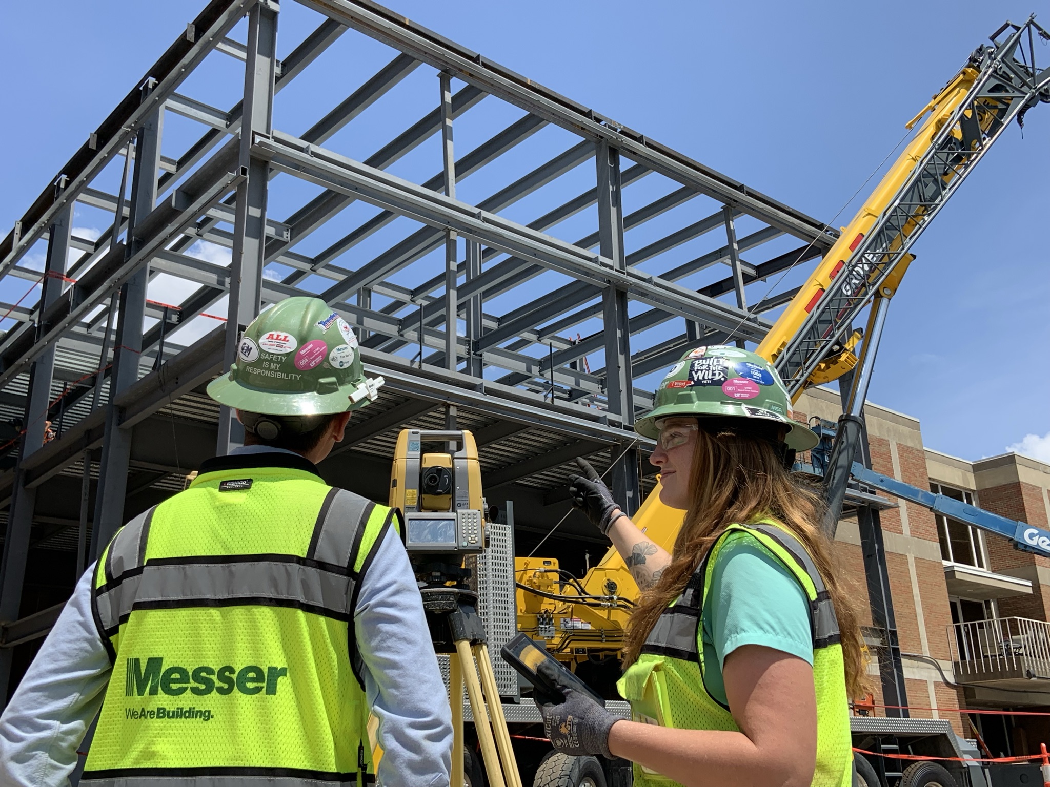 Messer Construction Co employees standing on a construction site in front of steel structure