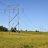 Grid towers and wind turbines over rural Iowa.