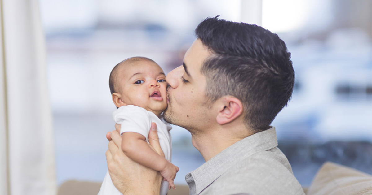 Man kissing a baby on the cheek 