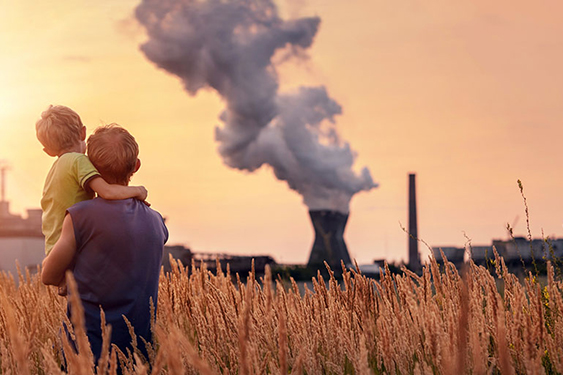 father holding son while looking at smokestack