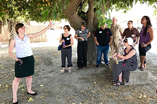 Tour guide talks to group of people outdoors 