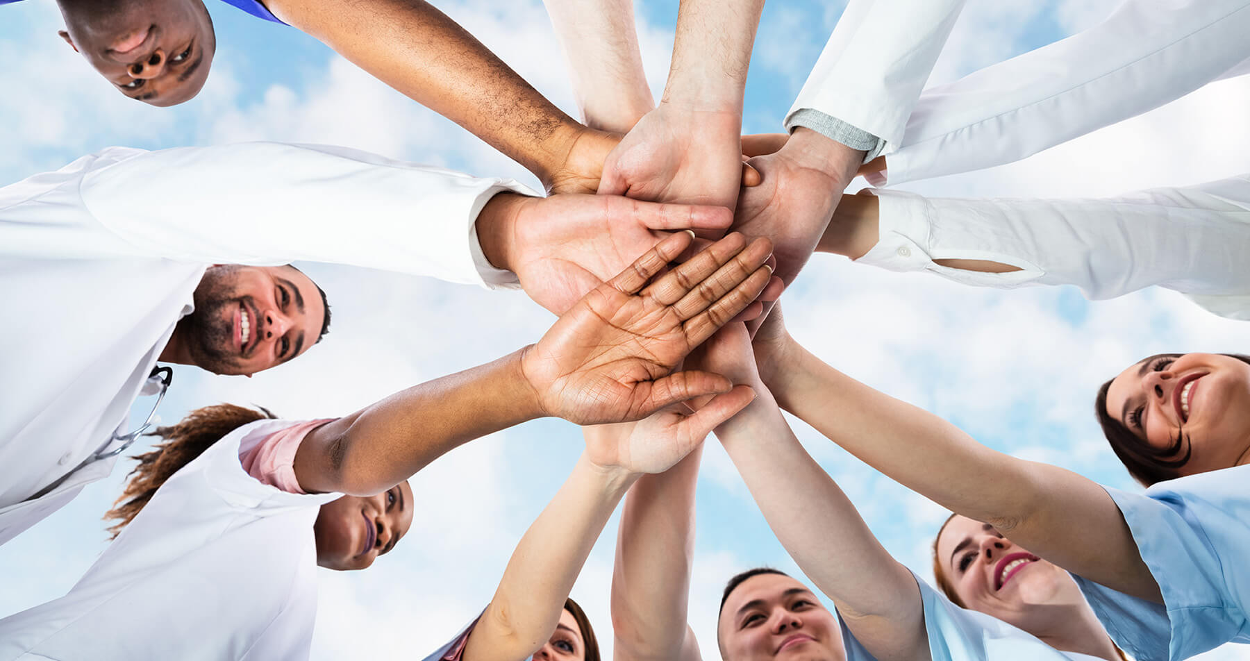 Photo: A diverse medical team of professionals with hands stacked together