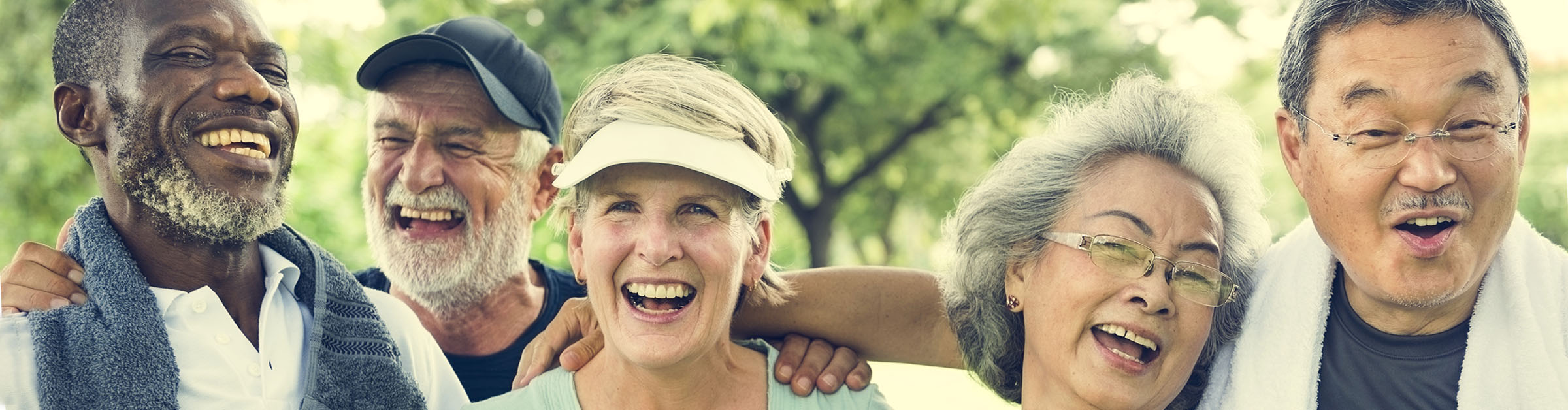 A group of physically active people of varied ages, genders, races, ethnicities laugh together