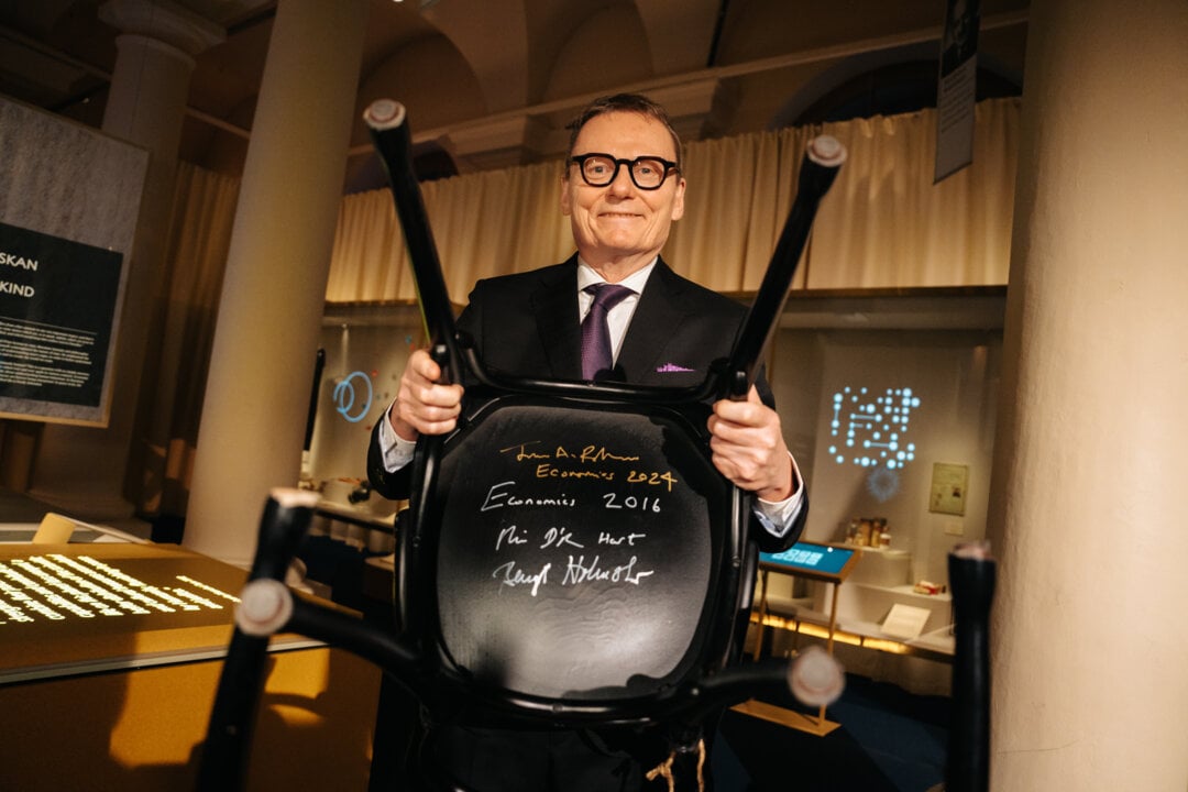 A man showing a chair with her signature