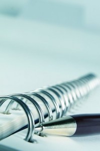 Closeup of the spirals in a notebook, pen laid alongside.