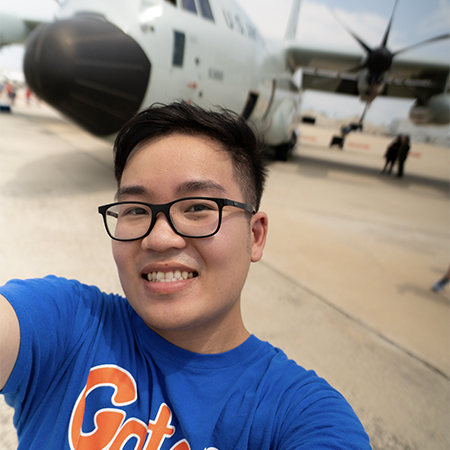 Tan on tarmac in frton of propeller plane