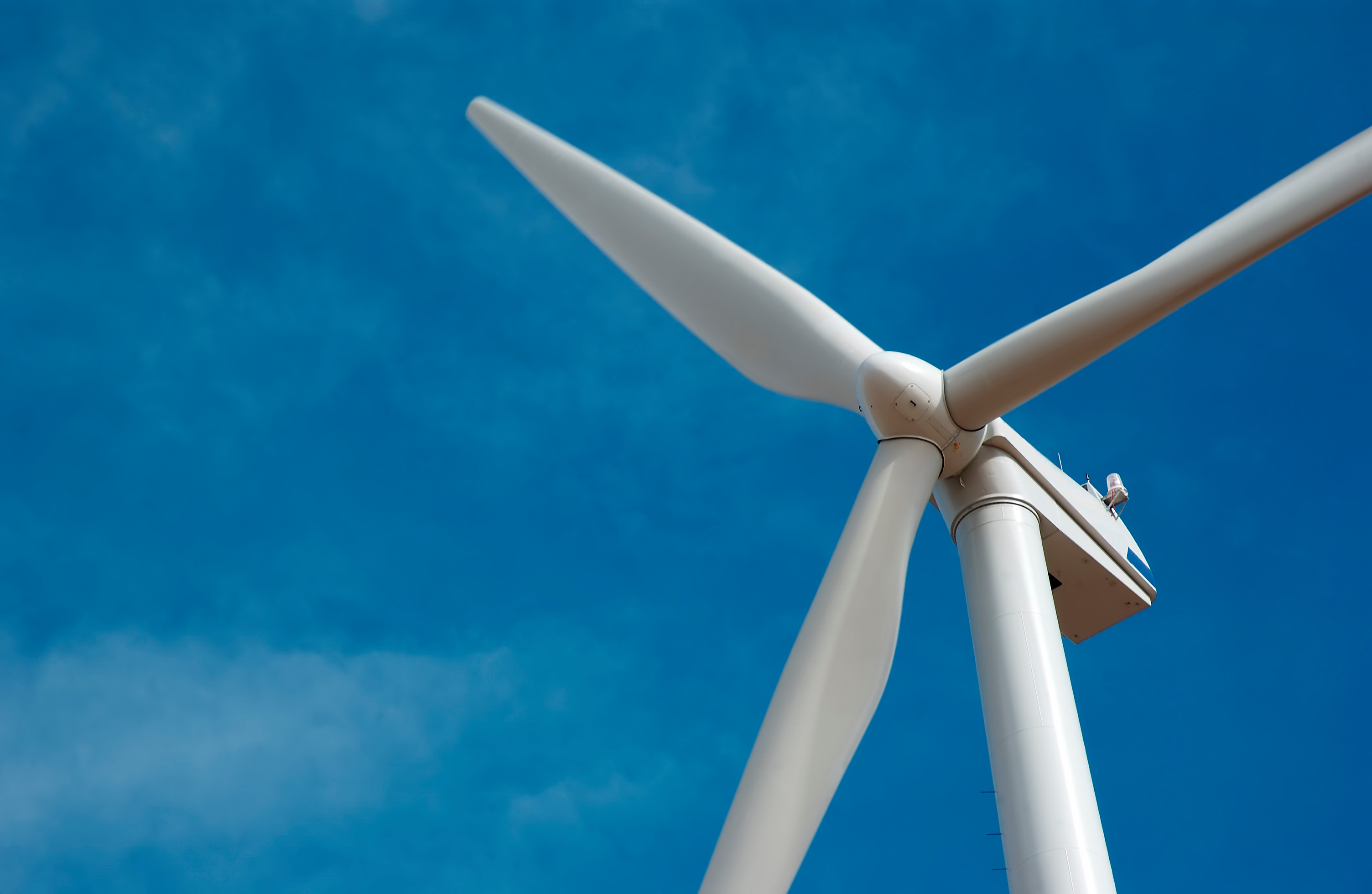 Close up image of the main turbine of a wind mill out at sea. Photo by Adobe Stock