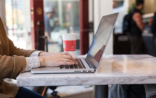 woman typing on laptop in cafe