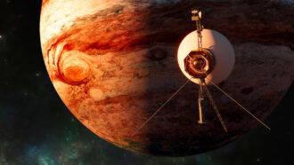 an illustration showing one of the Voyager space probes passing close to the planet Jupiter