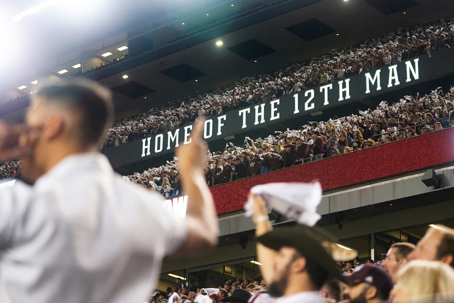 Aggie yell leader doing a pass back in front of the student section