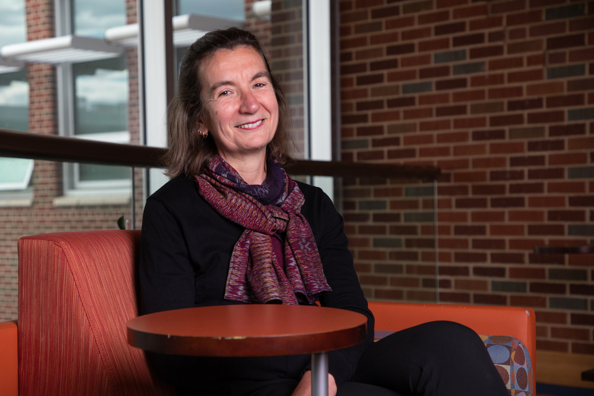 Sofia Reis sits in a chair in the Education Building at UM and smiles at the camera