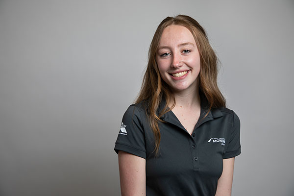 This is a headshot of a girl wearing a grey shirt with the University of Montana logo on it 