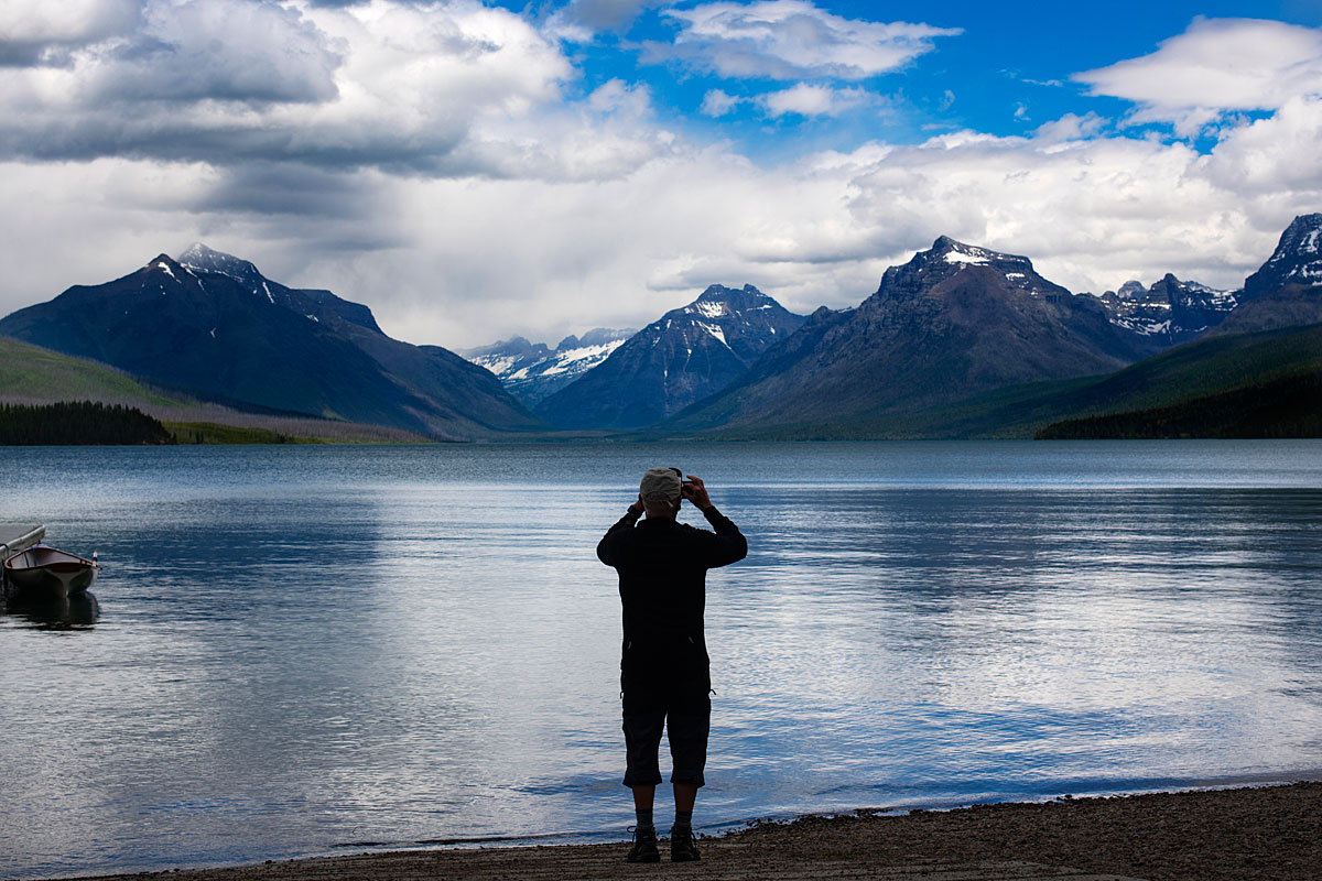 A man takes in the view from a lake in Glacier National Park.