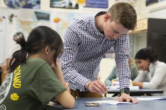 A picture of Simon Hill working with a student.