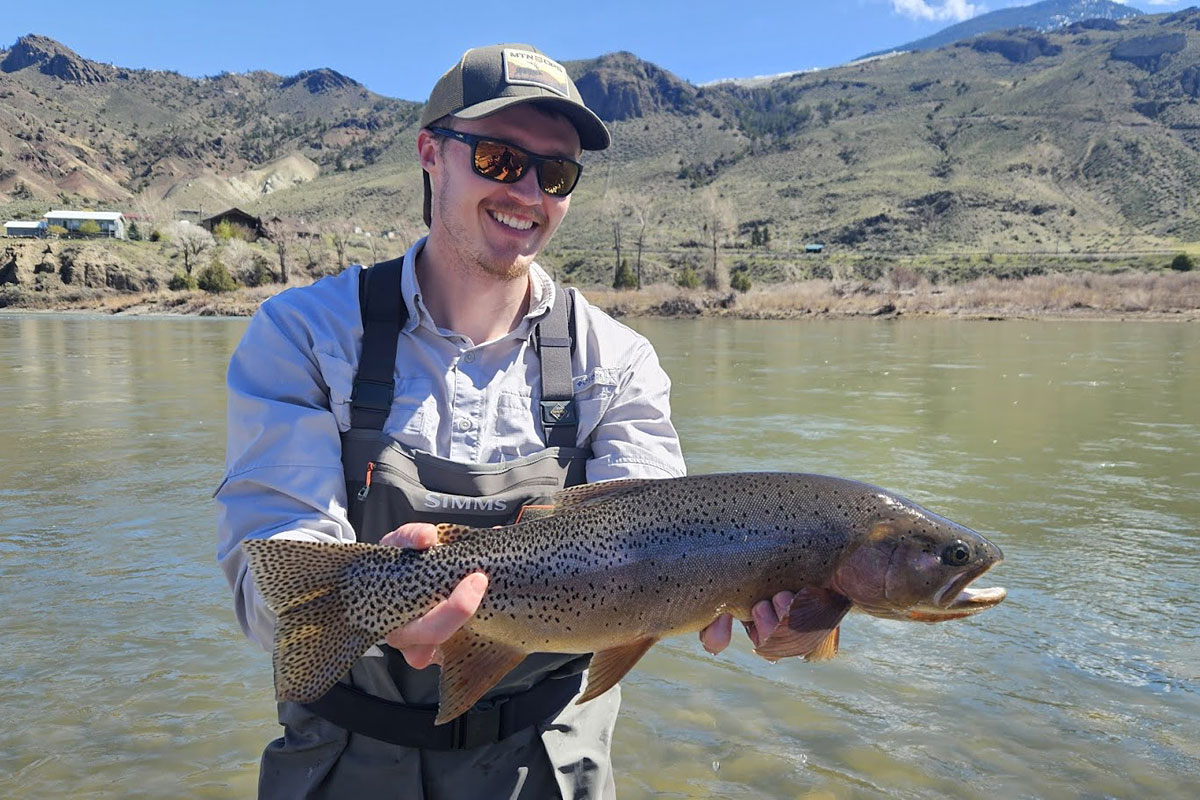 Colter Feuerstein holds a trout in the Yellowstone River.