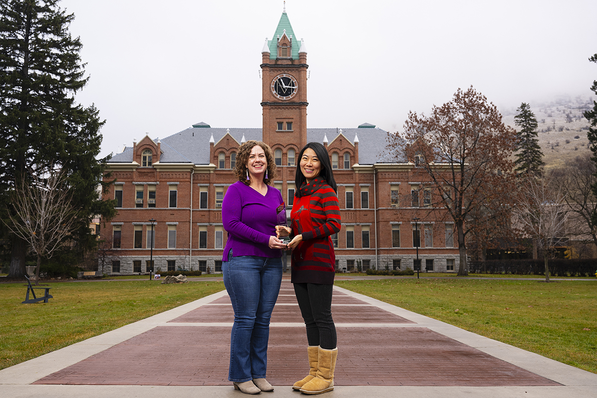 UM faculty members Anisa Goforth (left) and Jingjing Sun hold the 2024 Public Impact Research Award.