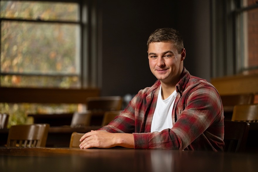 Kolter Stevenson, a UM student, sits next to a tree on the UM campus.