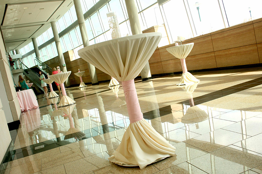 The atrium set with tables and decorations for a cocktail reception.