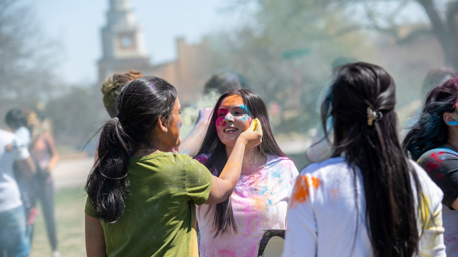 Students celebrating university day, walking with flags.