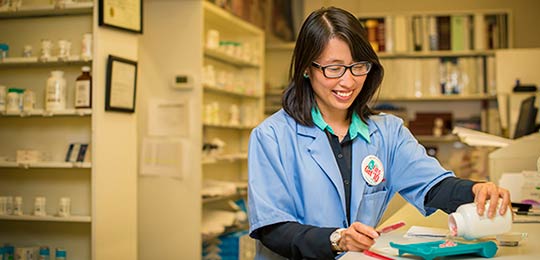 A student studies in a blue lab coat