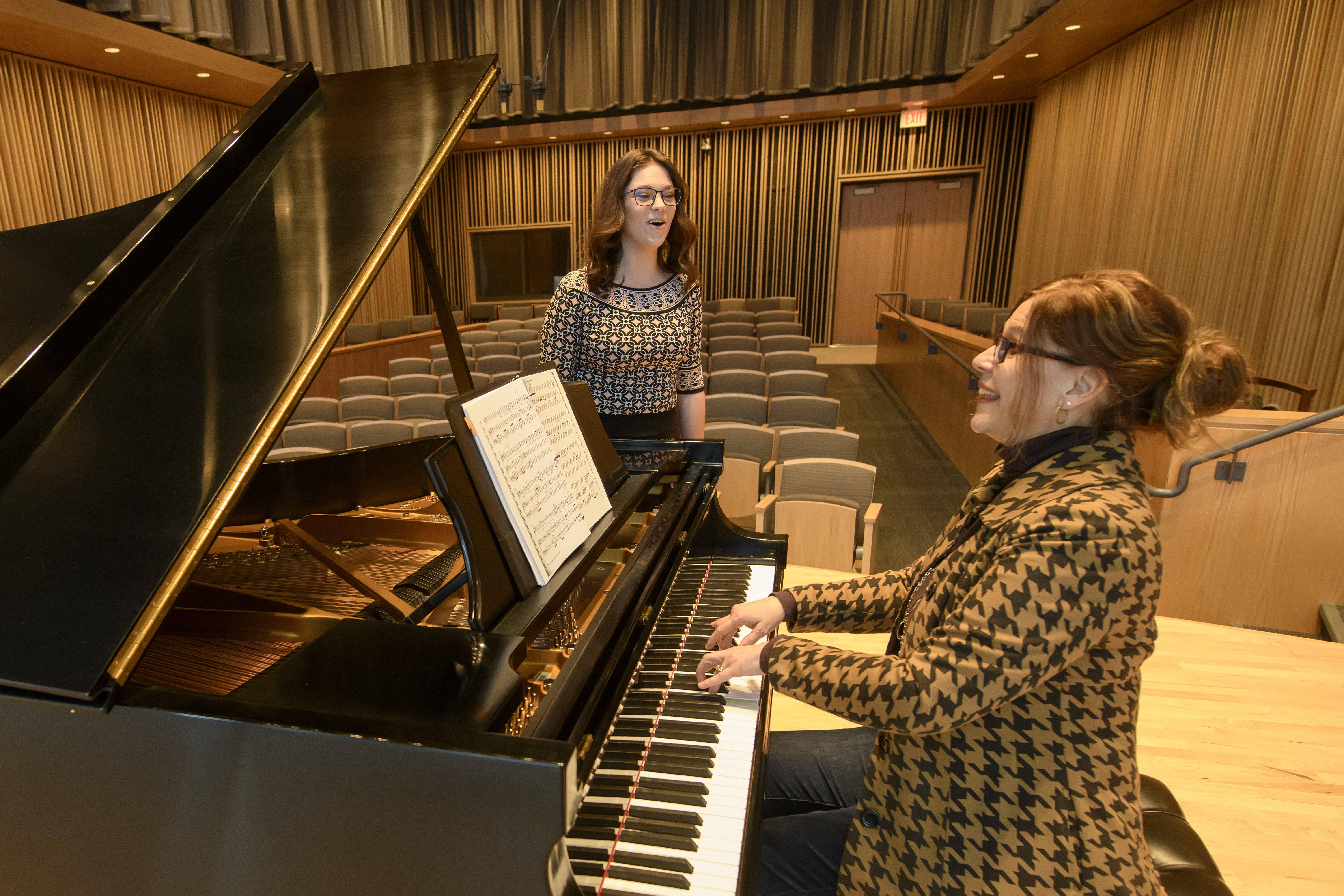 Student is singing next to a piano being played by an instructor.