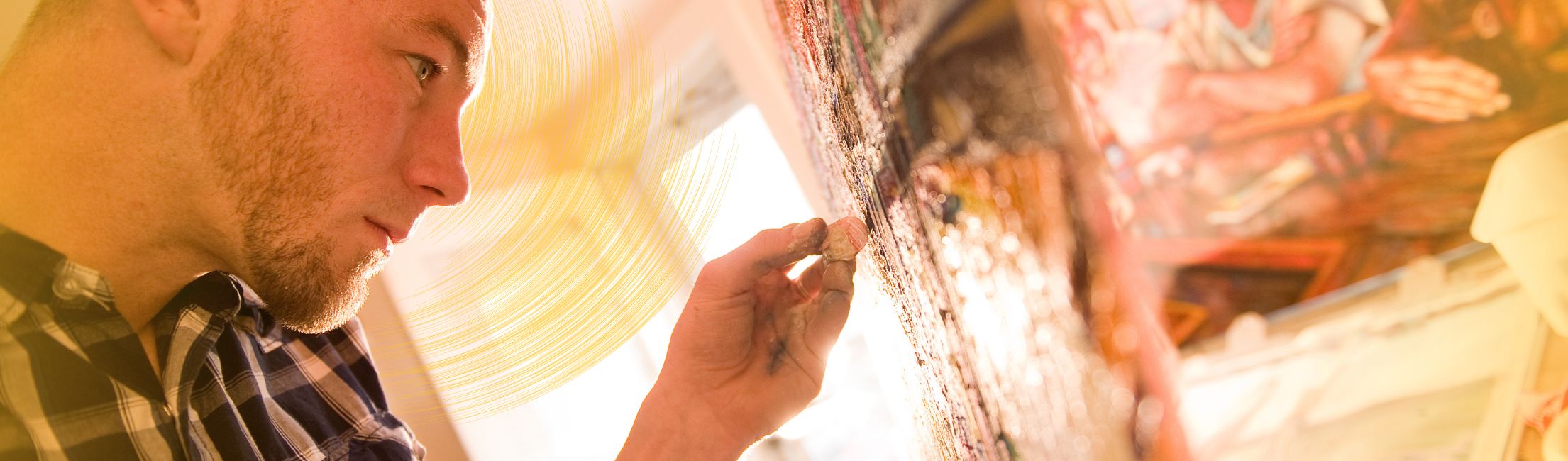 A student using a paintbrush on canvas