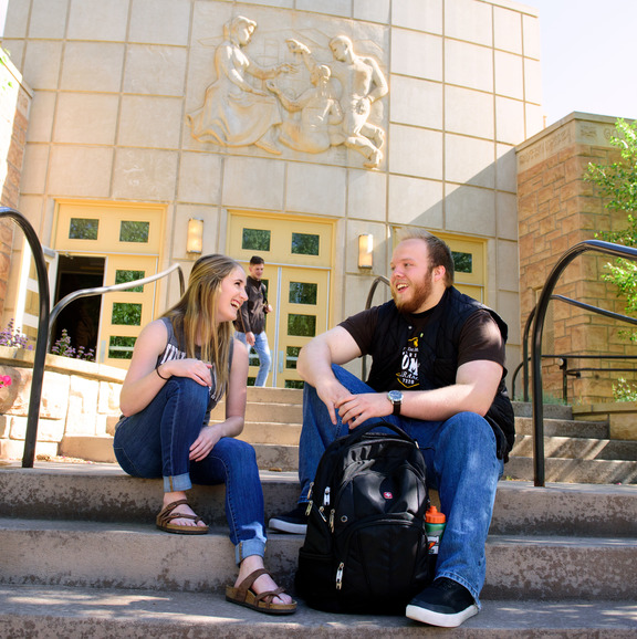 Students sitting on stairs outside College of Education building