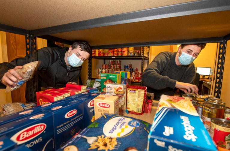 Two men sorting rice and pasta