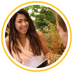 student sitting in prexy's pasture with a textbook