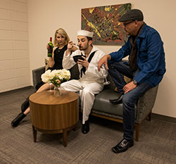 a woman and two men sitting on a couch